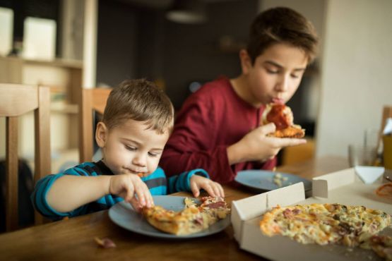 Zwei Jungen essen Pizza.